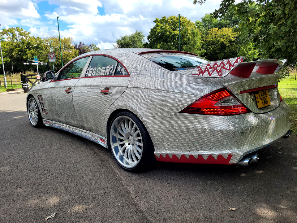 A crystal-encrusted 2005 Mercedes CLS500 with a sparkling exterior and luxurious features, including a V8 engine and red leather interior, is up for sale at £7,000.