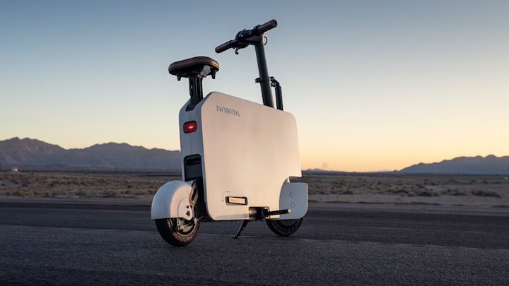 Honda's Motocompacto electric folding moped, MotorTrend's official pit bike for the 2024 Performance Vehicle of the Year event, simplifies racetrack logistics with its lightweight, foldable design and 12-mile range.