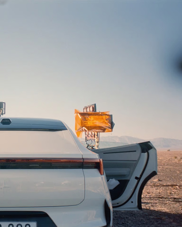 Polestar 4 takes a bold approach with dramatic visuals, featuring a large fabric parachute in a desert setting, signaling the much-anticipated electric SUV coupé hitting real roads.