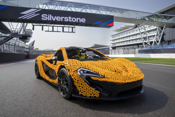 Lando Norris tests a life-size LEGO Technic McLaren P1 at Silverstone Circuit, the first LEGO model capable of completing a lap, showcasing the creativity and engineering prowess of LEGO and McLaren.