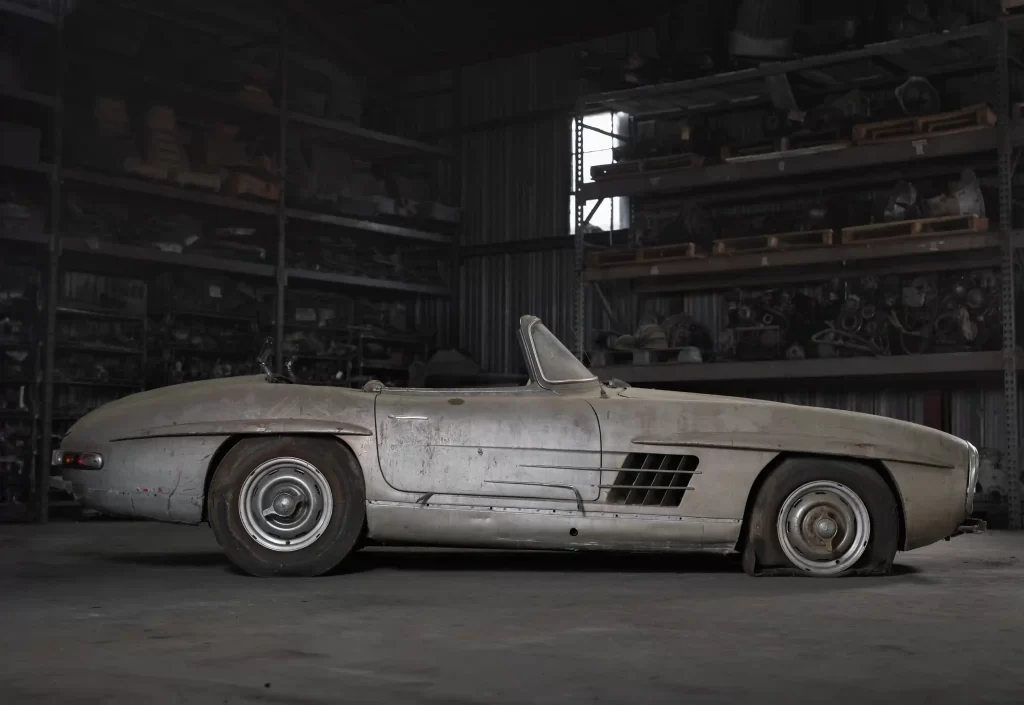 A rare 1957 Mercedes-Benz 300 SL Roadster, in need of restoration, is set to sell for £750,000 due to its exclusivity, despite looking like it belongs in a scrapyard.