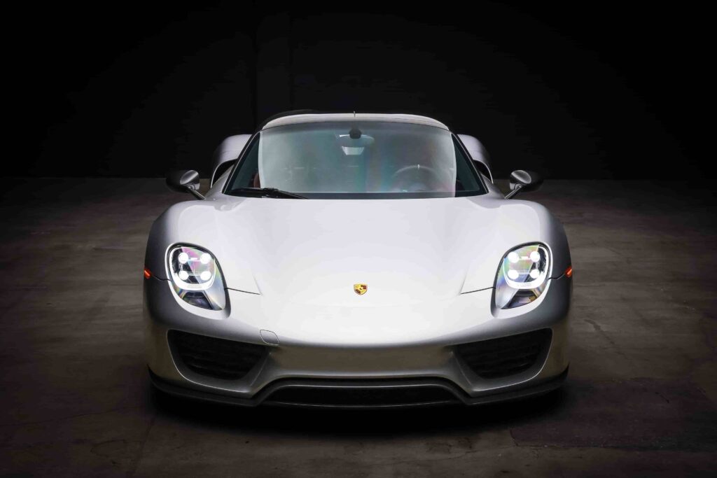 An ultra-rare 2015 Porsche 918 Weissach Spyder with only 170 miles is set to sell for £2.7 million. This limited-edition hybrid hypercar offers 887 horsepower and high-end racing features.