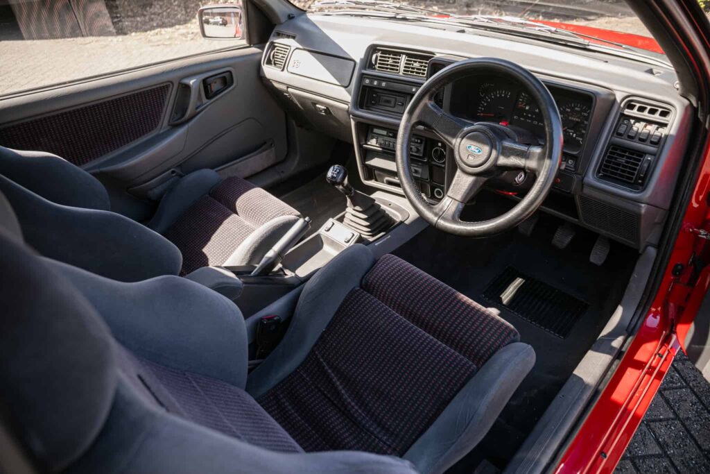 A rare Ford Sierra RS Cosworth in rosso red, once owned by a duke and racer, is set to fetch £90,000 at auction - over five times its original 1986 price.